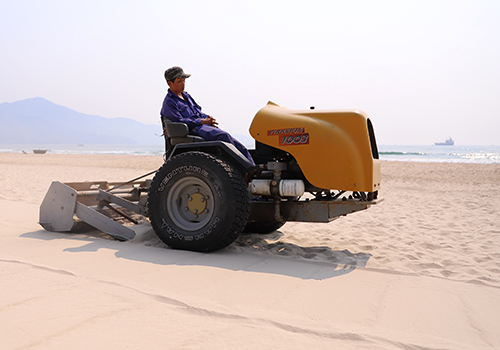 Công nhân điều khiển máy sàng cát lấy rác trên bãi biển Đà Nẵng. Ảnh: Nguyễn Đông.